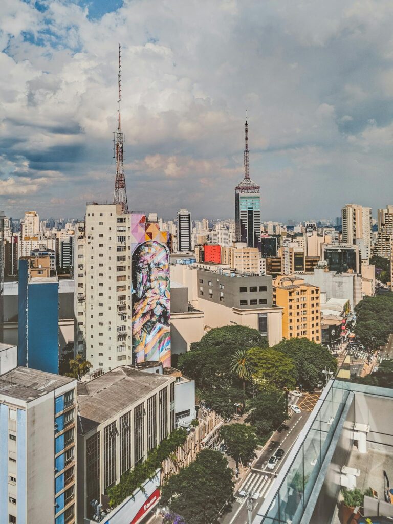 From above cityscape of Sao Paulo city downtown with modern high rise houses and telecommunication towers and with street art picture on facade of building